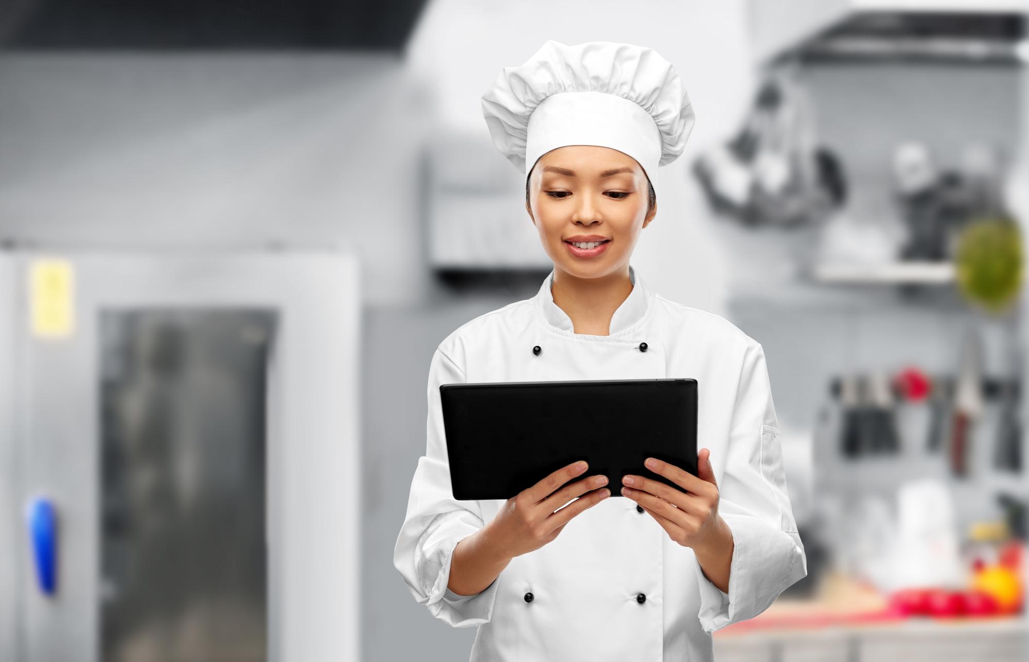 Szef kuchni pracujący z tabletem w high-tech kuchni